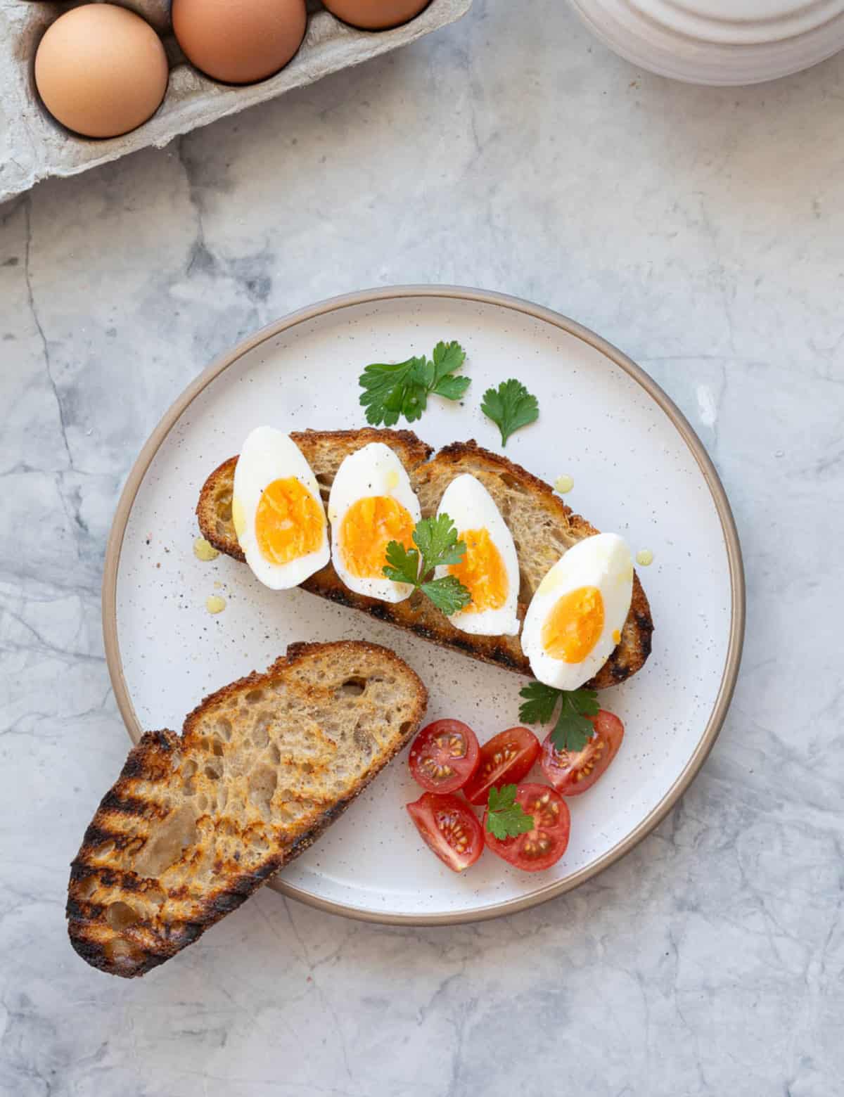Slices of sour dough toast topped with wedges of hard boiled eggs.
