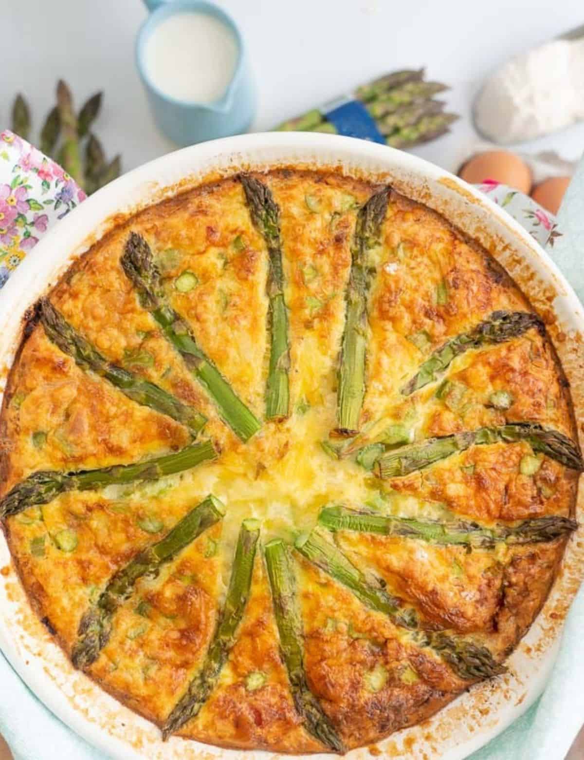 A quiche topped wait asparagus spears.
