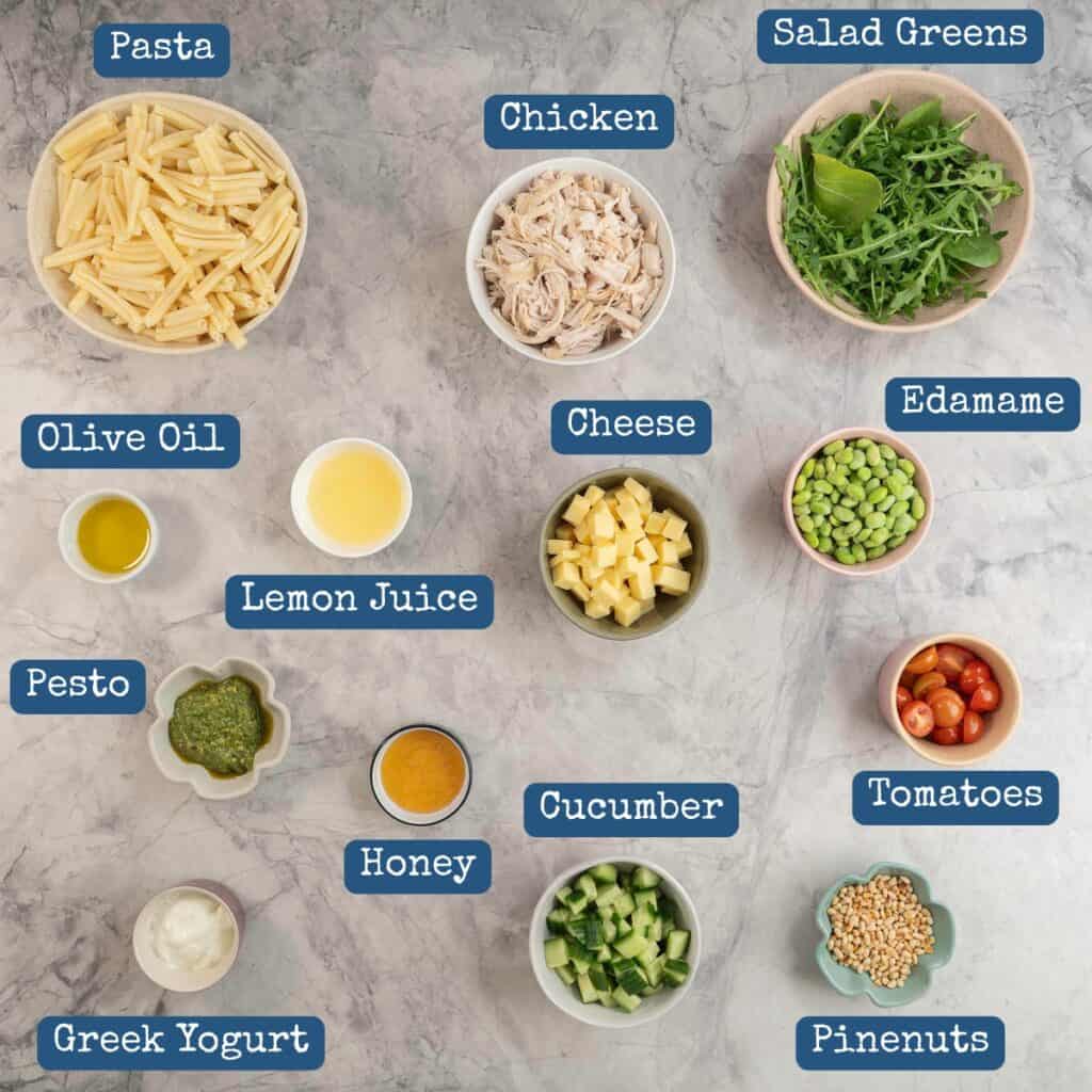 Ingredients for pasta salad on bench top with text overlay.