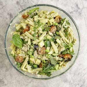 Large glass bowl on bench top with protein salad mixed together inside.