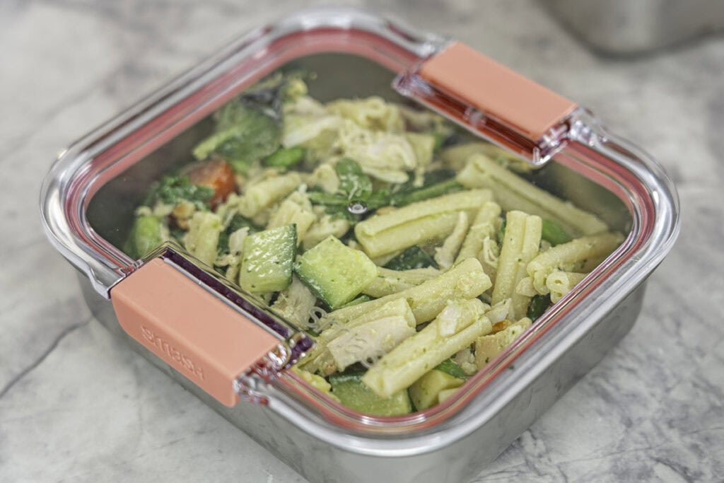 Stainess steel container with clear lid on, protein salad inside.
