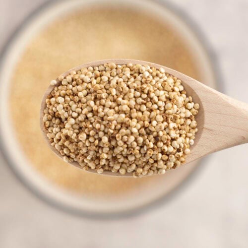 Puffy quinoa on a small wooden spoon.