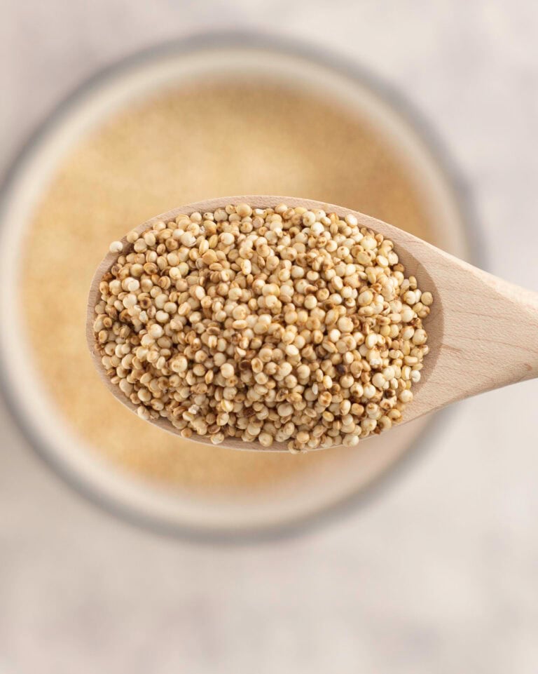 Puffy quinoa on a small wooden spoon.