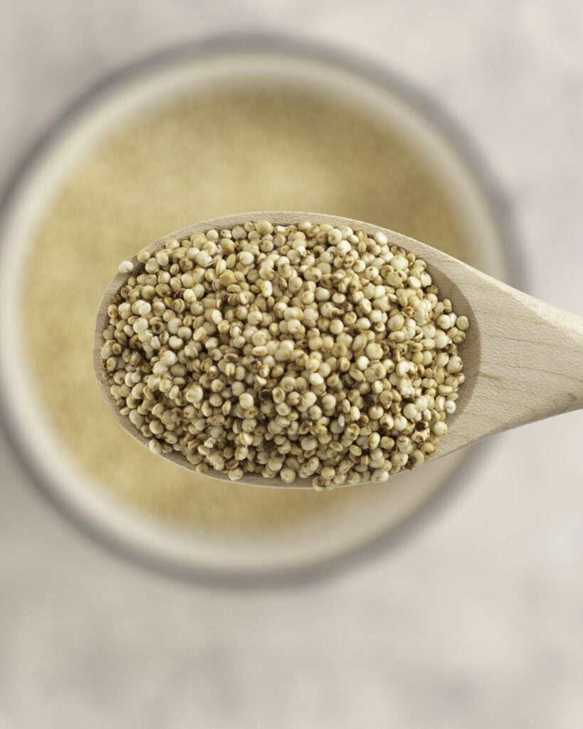Puffy quinoa on a small wooden spoon.