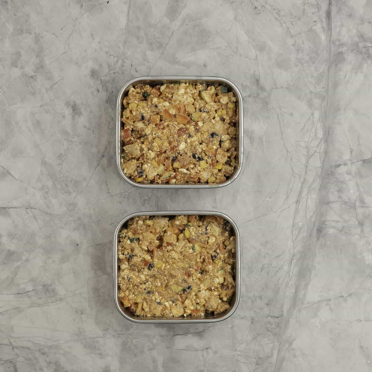 Protein Chicken enchilada mix portioned into stainless steel microwaveable square containers. 