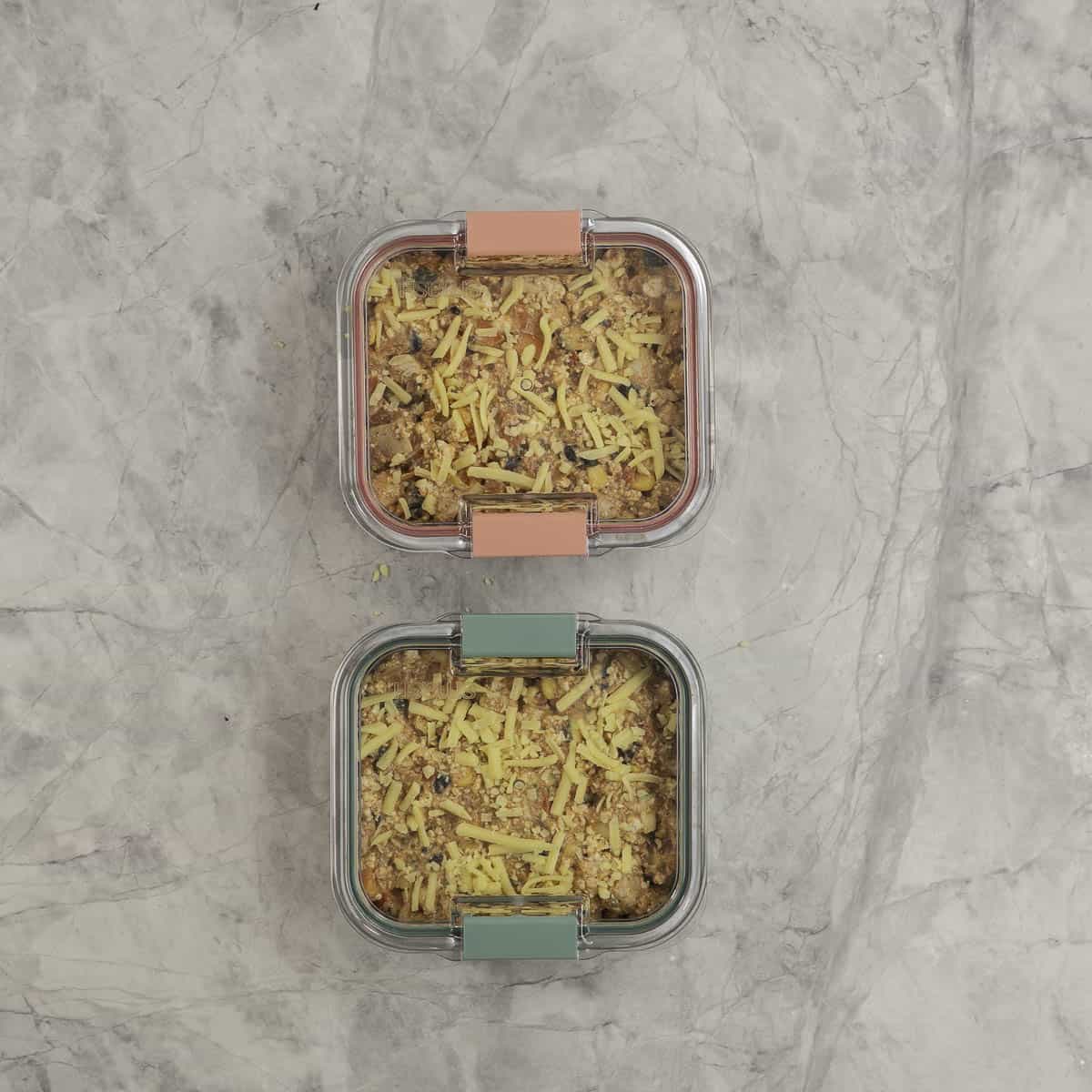Protein Chicken enchilada mix portioned into stainless steel microwaveable square containers with lids on top.