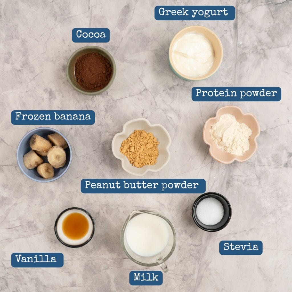 Ingredients for smoothie in small ramekins on a marble bench top with text overlay.