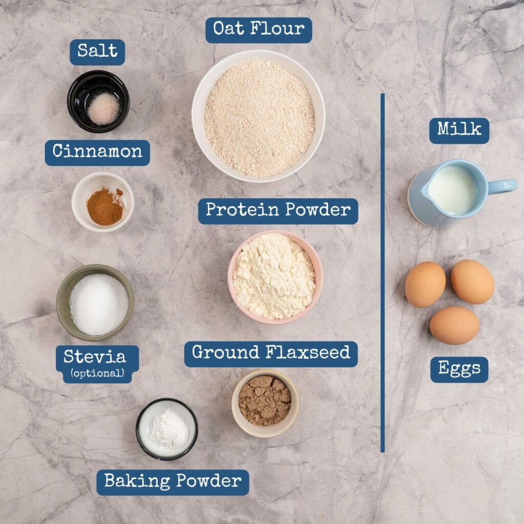 Ingredients for protein pancake mix on benchtop with text overlay.