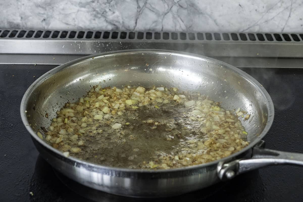Diced onion sautéing in a pan.