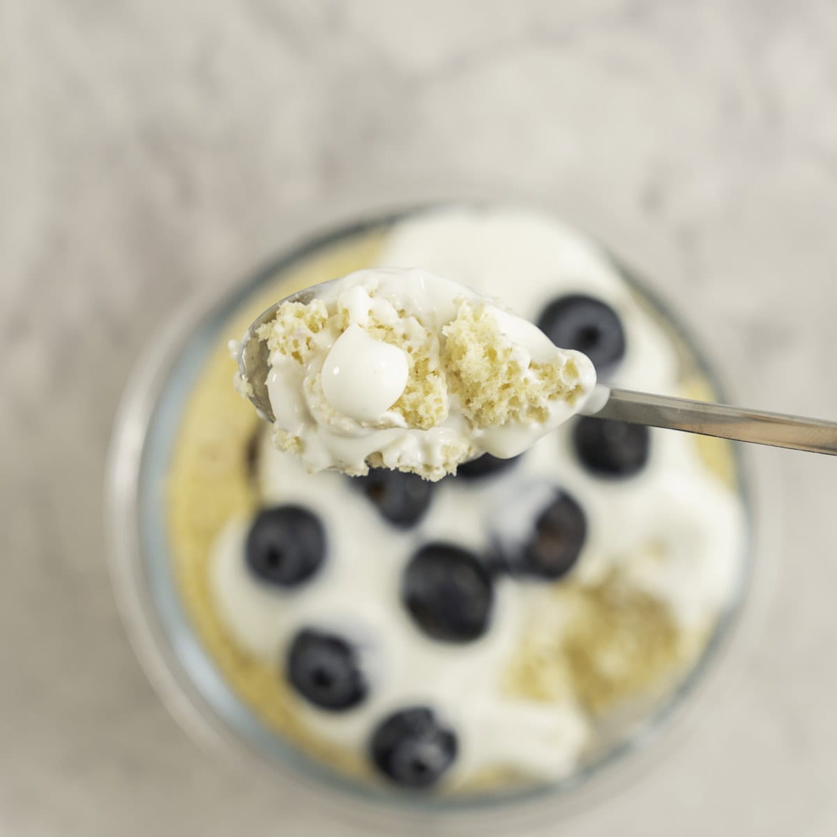 Pancake scooped with a teaspoon from glass ramekin below.