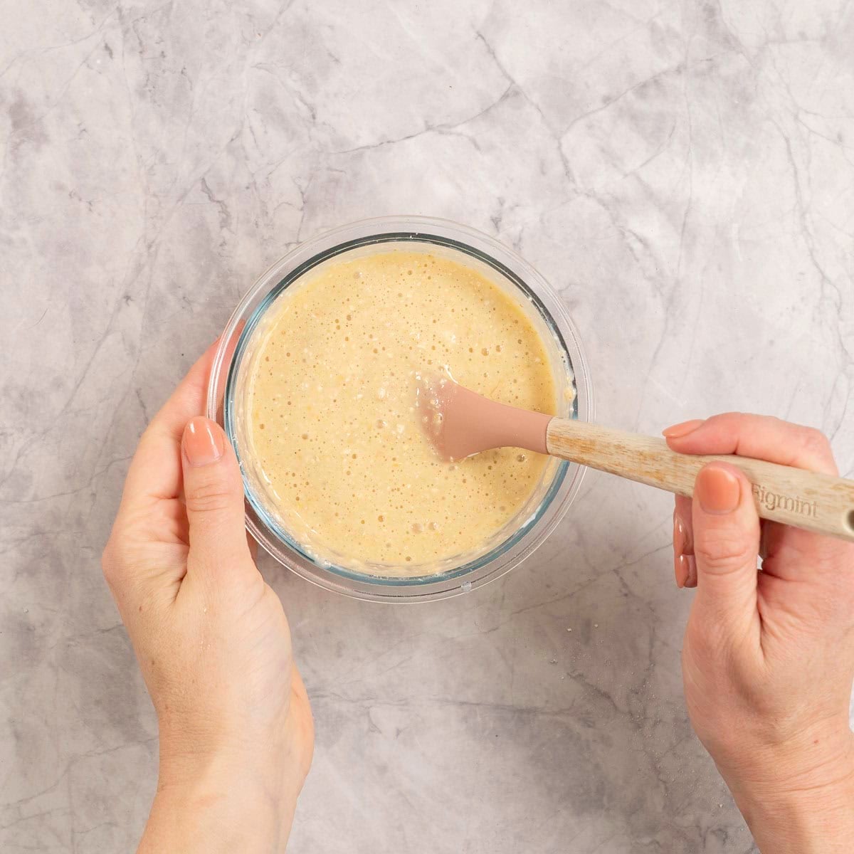 Ingredients for protein pancake in a small glass ramekin being mixed together with spatula.
