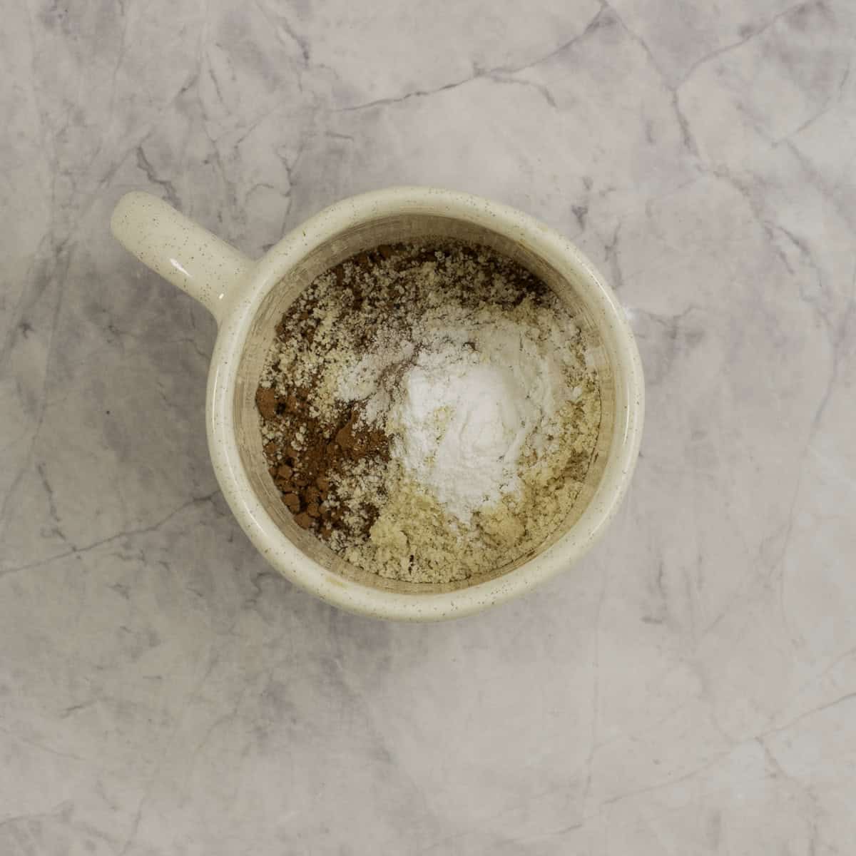 Dry ingredients for mug brownie inside a mug.
