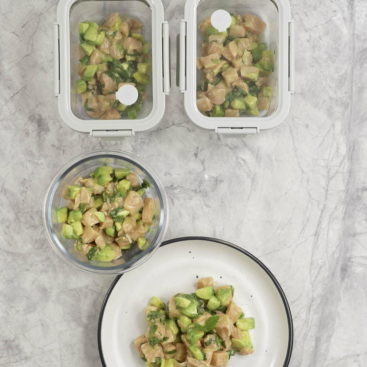 Salmon tartare portioned into 3 glass container and one dinner plate.